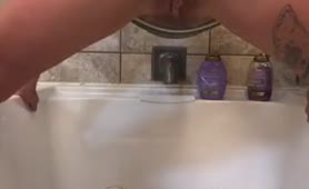 Tattooed babe peeing in bathtub