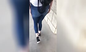Blonde woman walks outside and wets her jeans with a steady stream